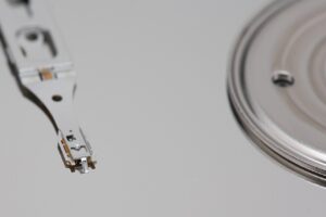 Open hard drive showing the read-write head over the platter during professional data recovery