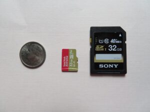 A full-size SD card and a microSD card shown next to a dime for size comparison